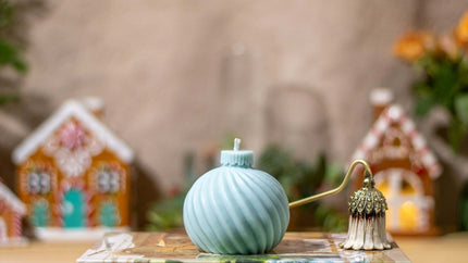 Handcrafted globe-shaped striped candle, made from natural wax with a festive holiday scent, perfect for Christmas décor.