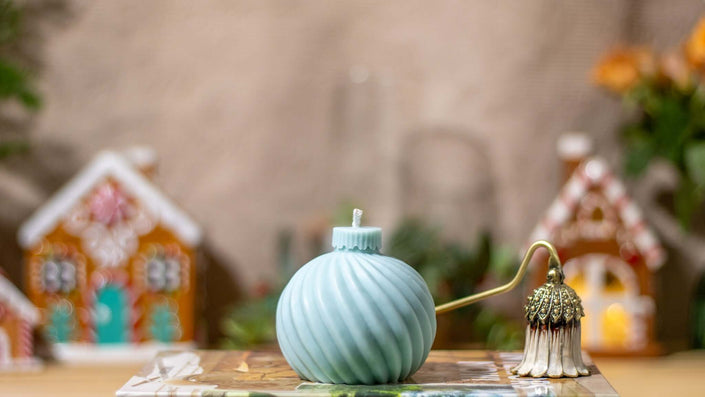 Handcrafted globe-shaped striped candle, made from natural wax with a festive holiday scent, perfect for Christmas décor.