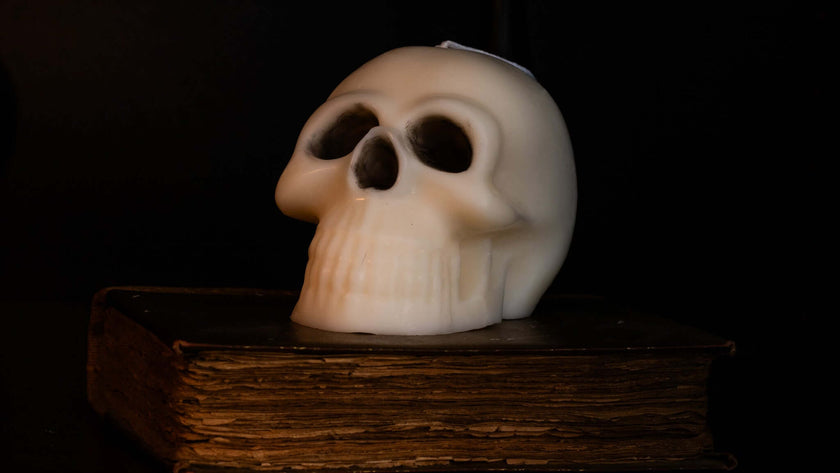Gothic skull scented candle in natural wax on an ancient book, perfect for Halloween decor.