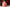 Pink floral-patterned candle with Christmas decorations in the background