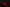 Red rose-shaped candle with a skull and blurred candles in the background