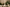 Decorative candle on a table setting with wine, plates, and greenery.
