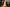Three tree-shaped candles in red, white, and green on a wooden board with a festive background.